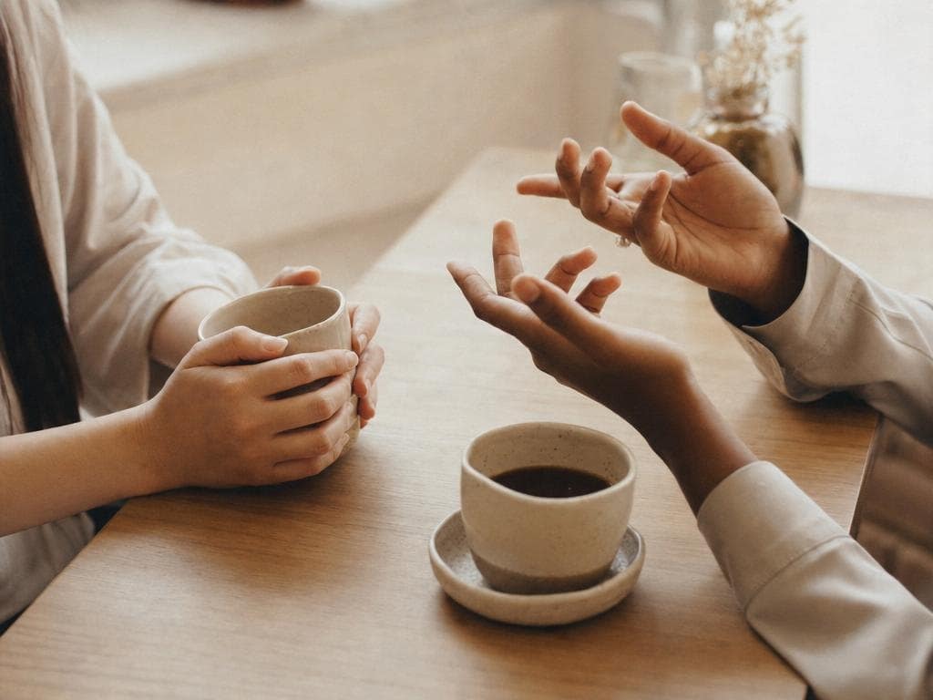 Two people in warm conversation across a cafe table